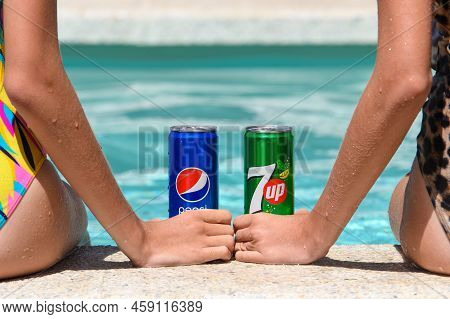 Novorossiysk - Russia, July 2022: Two Girls By The Pool With Cans Of Cold Pespi Cola And 7up On A Su
