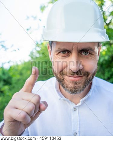 Portrait Of Man Taskmaster In Hardhat Pointing Finger Outdoors
