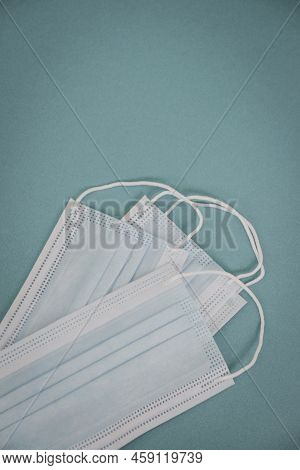 Tipical Surgical Masks With Rubber Ear Straps On Blue Background, Top View . Protection Concept.