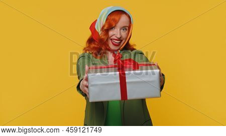 Smiling Redhead Young Woman Presenting Birthday Gift Box Stretches Out Hands, Offer Wrapped Present 