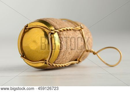 Cork Of Sparkling Wine And Muselet Cap On White Wooden Table, Closeup