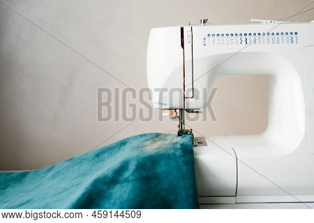 Part Of A Sewing Machine With A Needle And A Thread Pulled Into It And A Fabric That Is Sewn