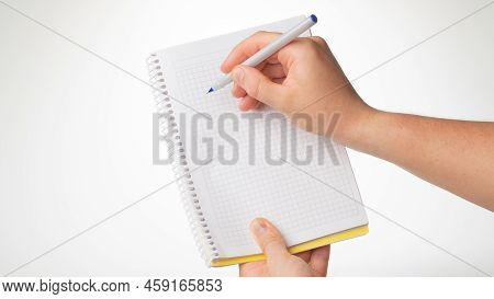 Mens Hand Hold A Notebook, A Pen In Her Right Hand Writes In A Notebook In A Cage. High Quality Phot