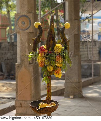 A Trishool Worshiped With The Lemons And Flowers In A Hindu Goddess Temple