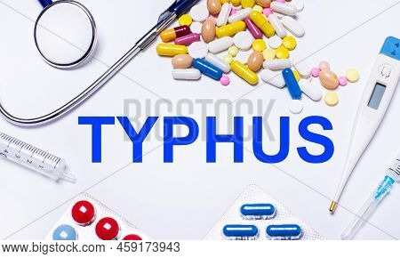 On A White Background Pills, Stethoscope, Syringe, Thermometer And Text Typhus. Medical Concept
