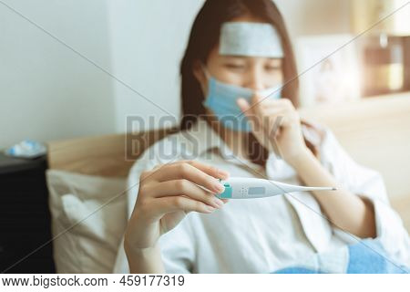 Asian Women Looking Body Temperature At Oral Thermometer For Diagnosing Flu From Coronavirus (covid-