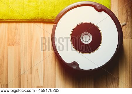 Robot Vacuum Cleaner On Laminate Wood Floor With Carpet Cleaning
