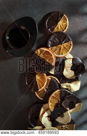 Fruit Chips With Chocolate And A Cup Of Coffee. Apple And Orange Chips. Vertical Photo On Dark Backg