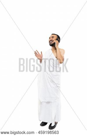 Man Wearing Ihram Clothes Using Smartphone To Make A Call