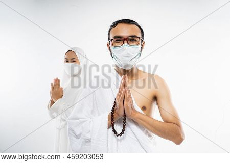 Man Wearing Ihram Clothes And Mask With Salam Gesture