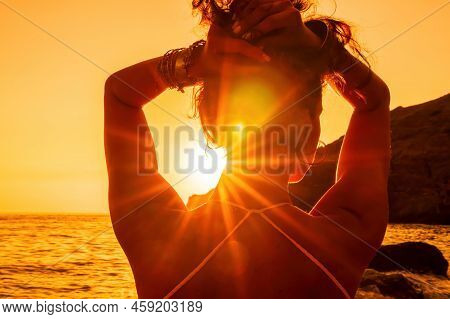 Middle Aged Well Looking Woman In White Swimsuit And Boho Style Braclets Practicing Outdoors On Yoga