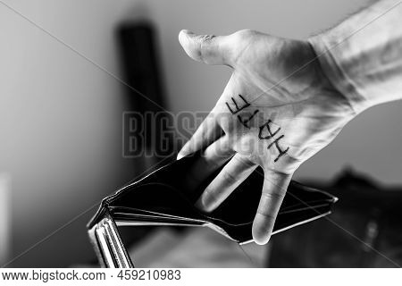 Monochrome Image, Caucasian Man Showing Hes Empty Wallet, The Word Hate Is Written On Hes Palm, Conc