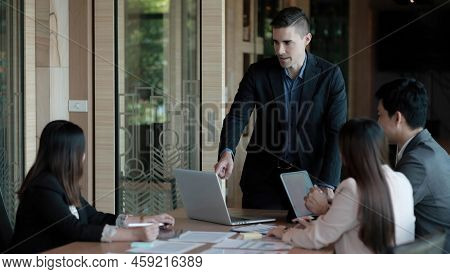 Business People Showing Team Work While Working In Board Room In Office Interior. People Helping One