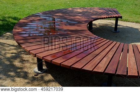 Circular Bench Made Of Brown-red Teak Wood. Tropical Impregnated Podia Boards For Sunbathing Visitor