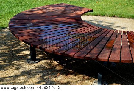 Circular Bench Made Of Brown-red Teak Wood. Tropical Impregnated Podia Boards For Sunbathing Visitor