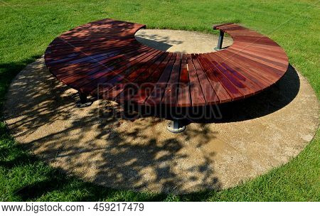 Circular Bench Made Of Brown-red Teak Wood. Tropical Impregnated Podia Boards For Sunbathing Visitor