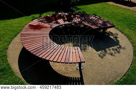 Circular Bench Made Of Brown-red Teak Wood. Tropical Impregnated Podia Boards For Sunbathing Visitor