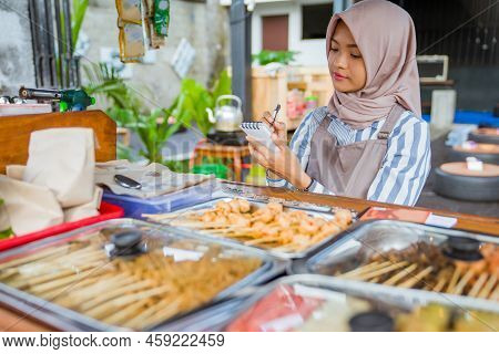 Muslim Woman Write A Report Of Her Food Business