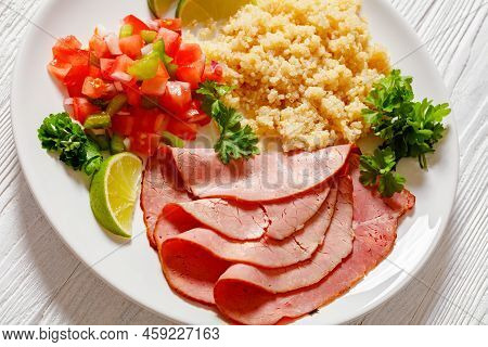 Close-up Of Thinly Sliced Roast Beef Fillet With Quinoa And Tomato Pepper Salsa On White Plate On Wh