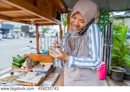 Muslim Seller Taking Order From Customer Through Phone