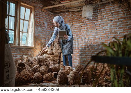 Craftswoman In Veil Holding Tablet Checking Water Hyacinth Woven Crafts