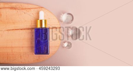 Top View Of Cosmetics Dropper On Wooden Slice With Flass Balls Near It.earth Tones, Good As Cosmetic