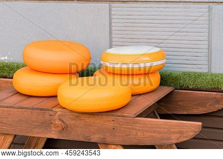 Orange Cheese Wheels Laying Down On The Wooden Country Table. Village. Eating. Food. Nutrition. Milk