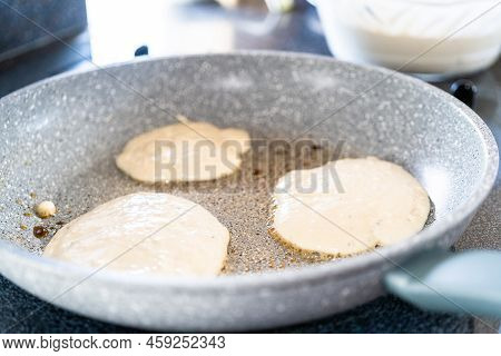 Frying Kefir Based Pancakes In Cooking Pan On An Electric Stove.