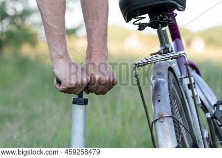 Hands Of A Man Seen Pumping A Bicycle Tire Using A Stand Alone Hand Pump. Pumping Up Bicycle Tires I