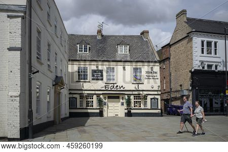 Grantham, Lincolnshire, England- August 2, 2022. Eden Restaurant Exterior View With Couple Walking B