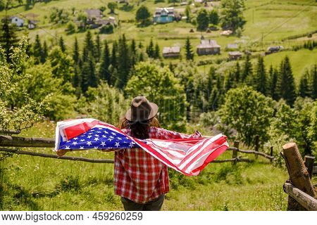 A Young Woman Stands On A Mountain And Holds The Us Flag In Her Hands. American Independence Day Cel