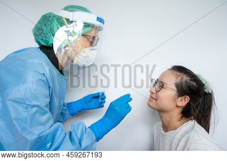 Healthcare Worker Trying To Taking A Nasal Swab From Asian Woman For Testing Diagnosis Of Covid-19 I
