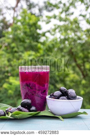 Jamun Or Malabar Plum Juice In A Glass With Fruit In A Bowl With Leaves Isolated On Wooden  Backgrou