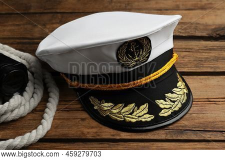 Peaked Cap And Rope With Binoculars On Wooden Background