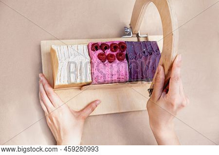 A Soap Maker Cuts Multi-colored Pieces Of Soap On A Special Wooden Device. View From Above. Only Han