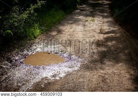 Selective Blur On A Muddy Water Puddle On A Ground Dirtpath In The Countryside, Wet, During A Rainy 