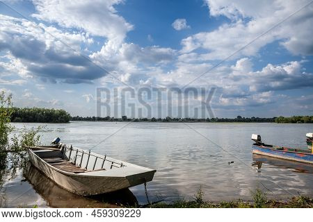 Panorama Of The Danube River In Serbia In Krcedin, Vojvodina, With Vintage Rowing And Motor Boats An