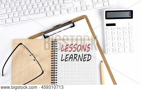 Notebook With The Word Lessons Learned With Keyboard And Calculator On White Background