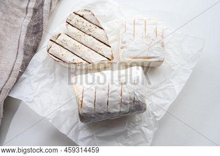 French Cheeses Heartshaped, Squared And Cylindrical Neufchatel Cow Cheese With Mold On White Paper,