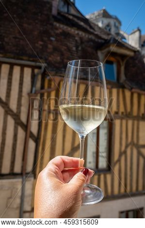 Tasting Of White Grand Cru Classe Chablis Wine With Old French Houses On Background, Burgundy, Franc