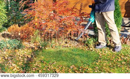 Leaves Blower Using Process. The Gardener Cleans The House Territory. Work In The Garden With An Ele