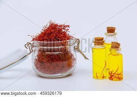 Glass Jar Filled With Red Saffron Stamens. And Saffron Drink On A White Background. Expensive Spice.