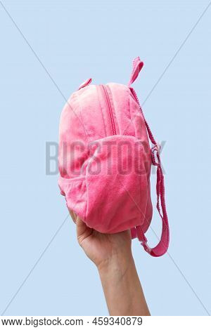 Pink Backback In Female Hand Isolated On Pastel Blue Color Background