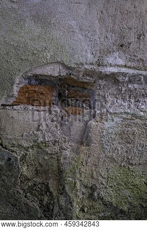 Old Delapidated Concrete Wall With Hole Exposing Red Brick Foundation