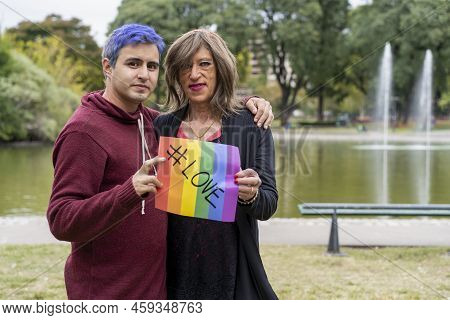 Love. Cheerful Queer Couple Holding A Message Supporting The Lgbt Community