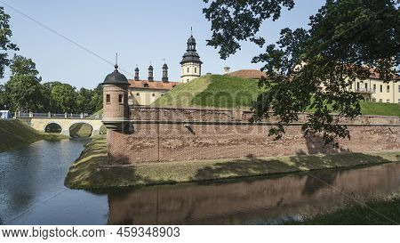 Moat Of Old Castle. Moat With Reflection In The Water And Trees. Sunny Summer Day. Palace, Tower, Co