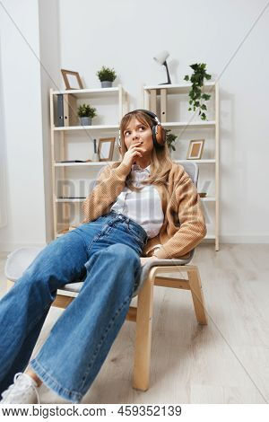 Dreaming Happy Young Blonde Lady In Warm Sweater In Headphones Looks Aside Listen Fav Songs Sitting 