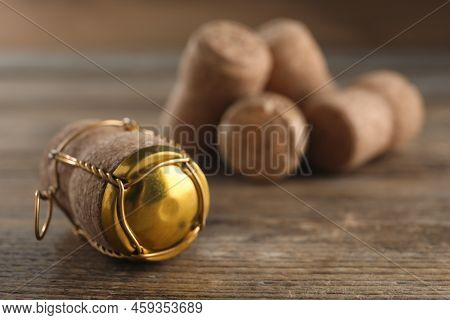 Cork Of Sparkling Wine And Muselet Cap On Wooden Table, Closeup. Space For Text