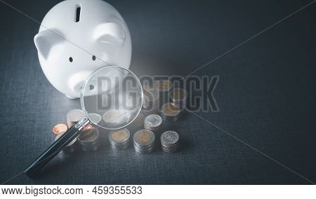 A Magnifying Glass, A Pile Of Coins, And A Piggy Bank, All On The Table, Financial And Money Deposit