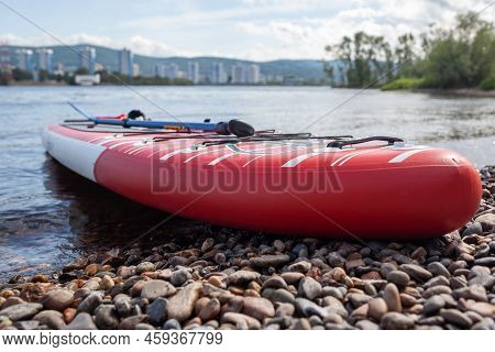 12.07.2022 Krasnoyarsk, Russia. Red Sup Board On The River Bank. Paddle Board On The Lake Shore. Sup
